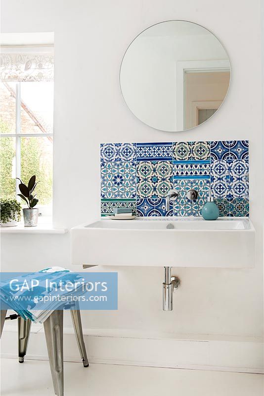 Patterned tiled splashback in white modern bathroom above sink  