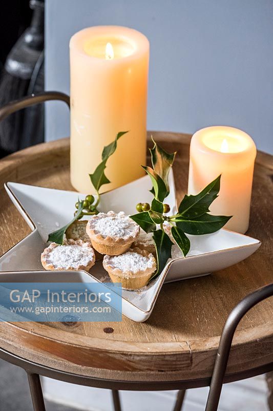 Mince pies and candles on side table 