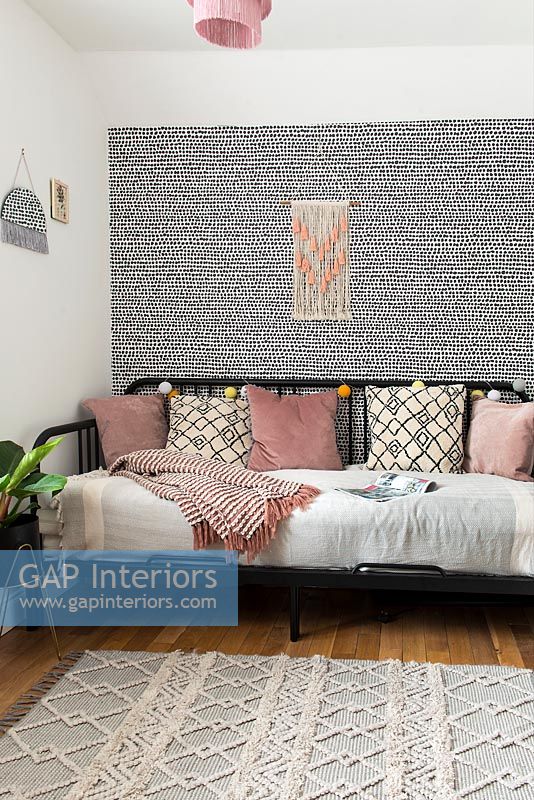 Patterned feature wall in modern bedroom with daybed 