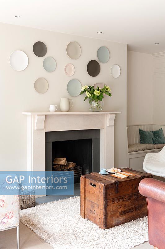 Fireplace with display of wall mounted plates above it in modern living room