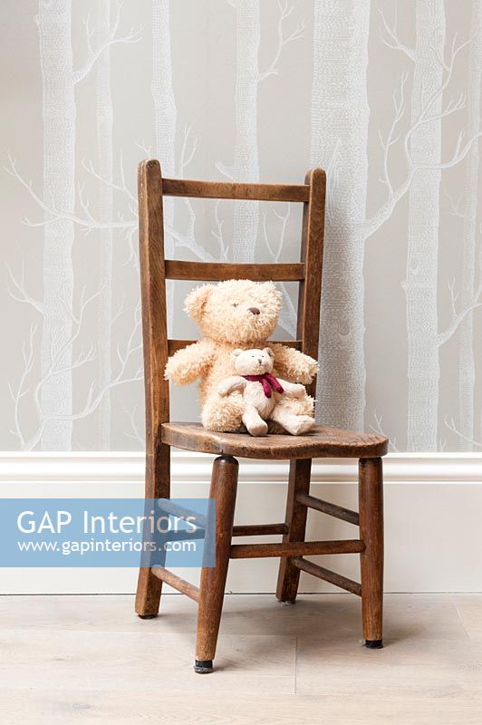 Teddy bear on small wooden chair 