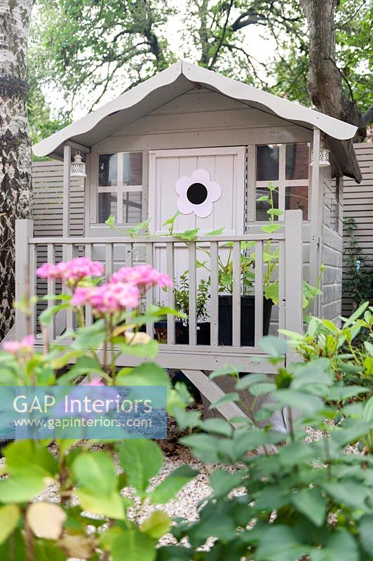 Decorative painted wooden playhouse in garden 