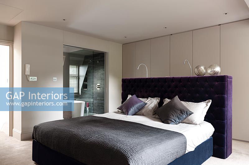 Modern bedroom with purple headboard 