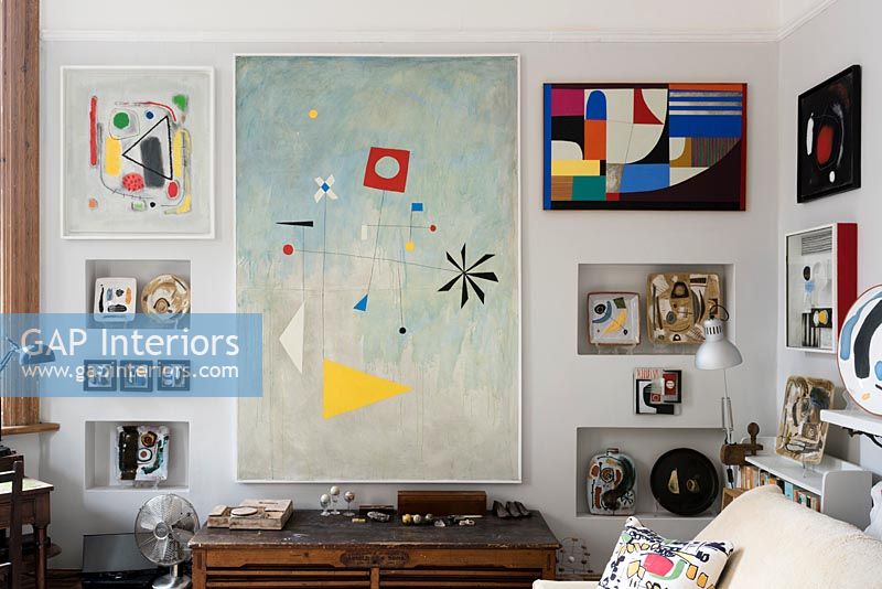 Wall covered in modern artwork in living room 