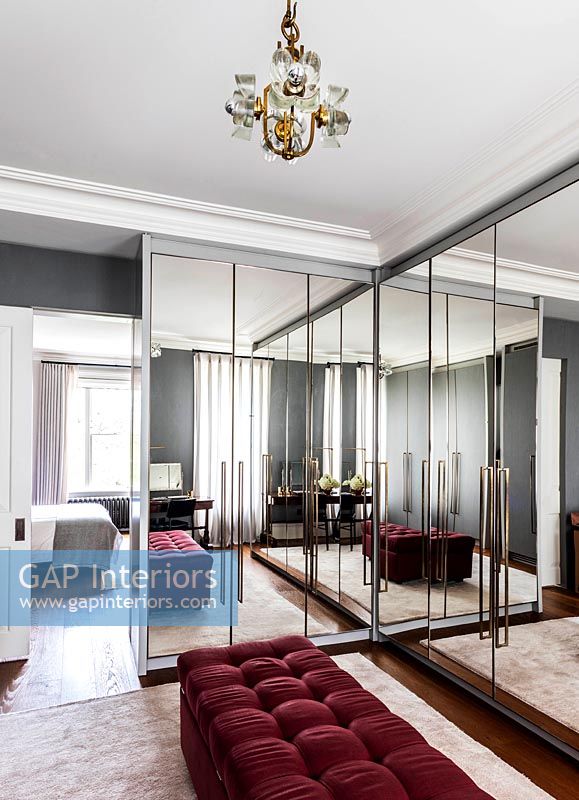 Large mirrored built-in wardrobes in retro style dressing room