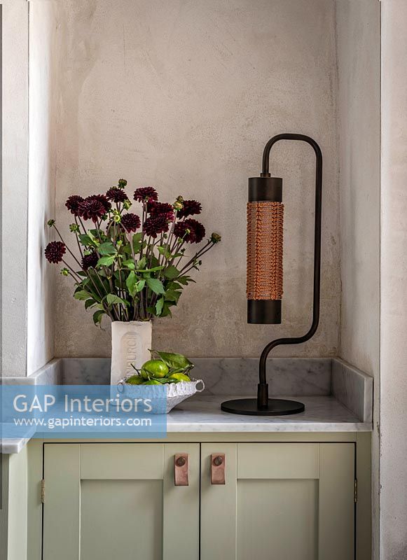 Modern lamp next to flower arrangement 