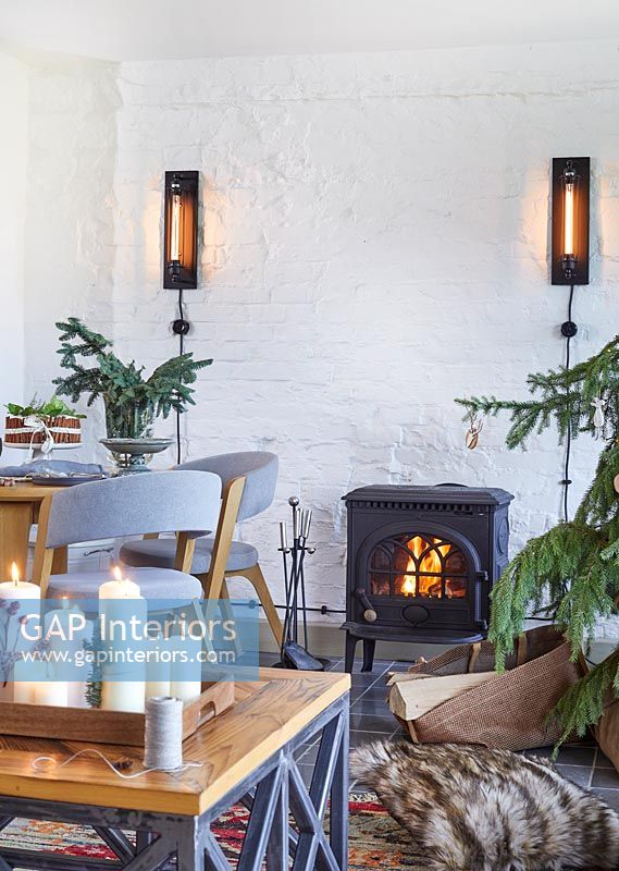 Lit wood burning stove in modern country living space at Christmas 