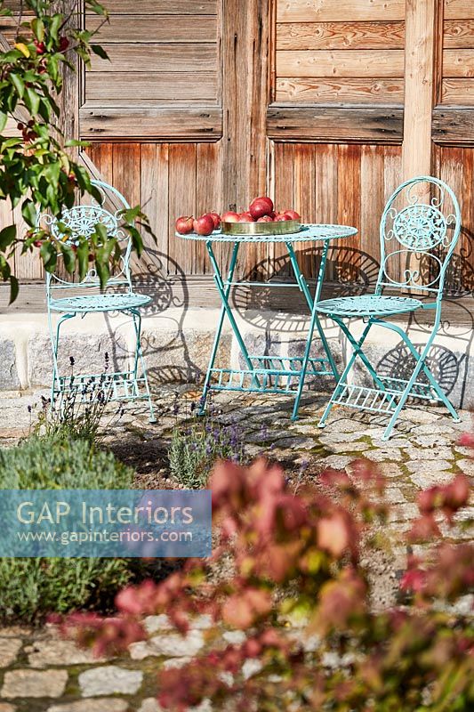 Small blue metal cafe style table and chairs on terrace 