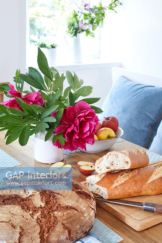 Fresh bread and flowers on modern country kitchen table 