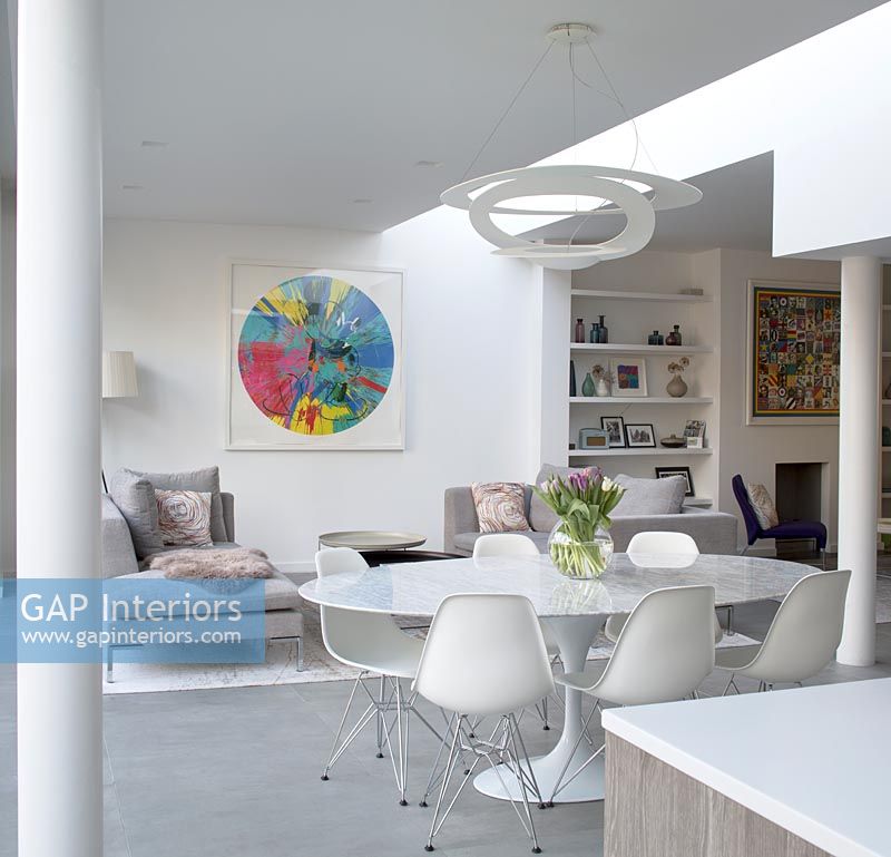White circular dining table and chairs in modern open plan living space 