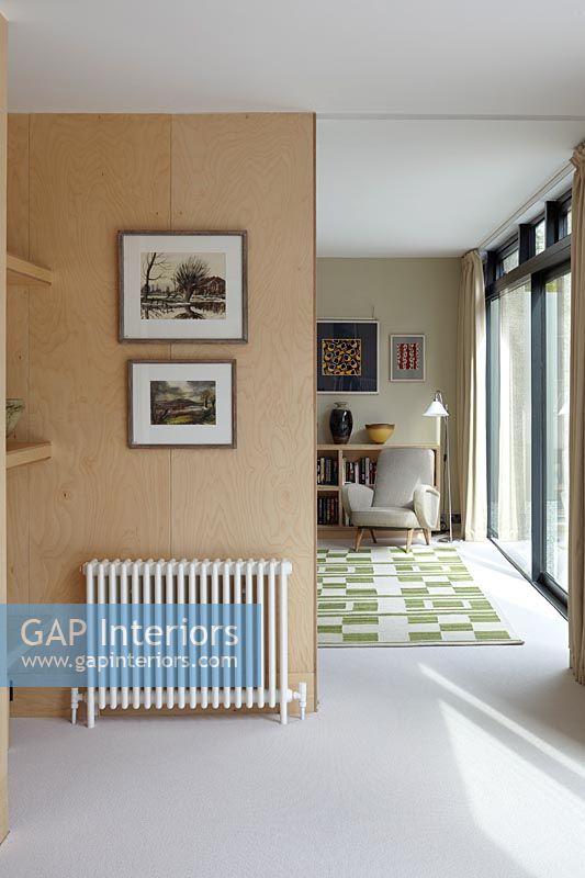 Radiator and pictures on partition wall in open plan living space 