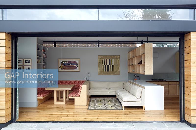 View through open patio doors to contemporary open plan living space 
