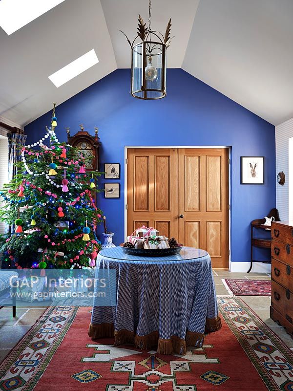 Blue painted hallway with central table and Christmas tree 