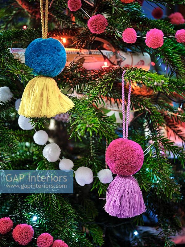 Colourful pompoms as Christmas tree decorations on tree 