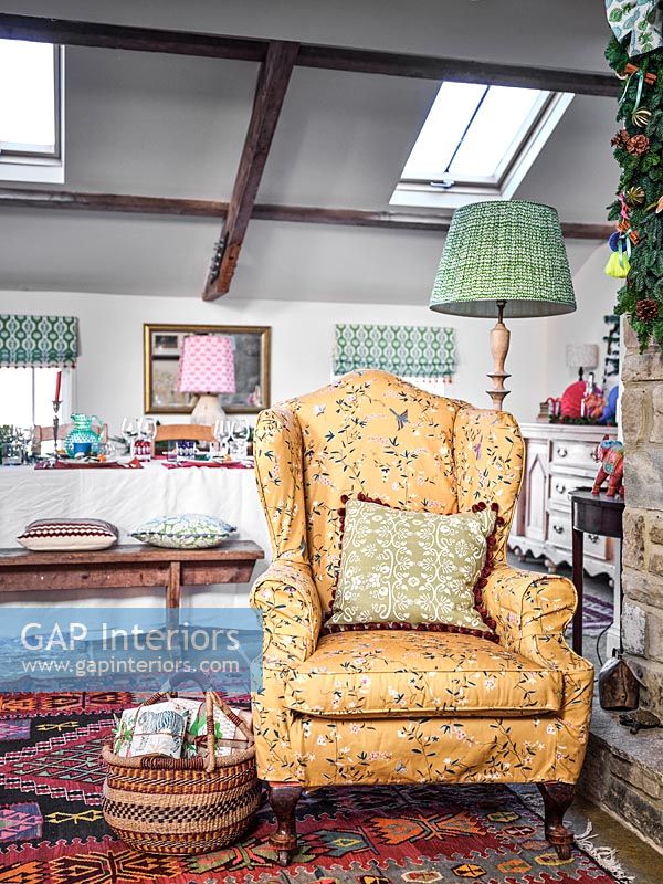 Floral fabric covered armchair in country dining room 