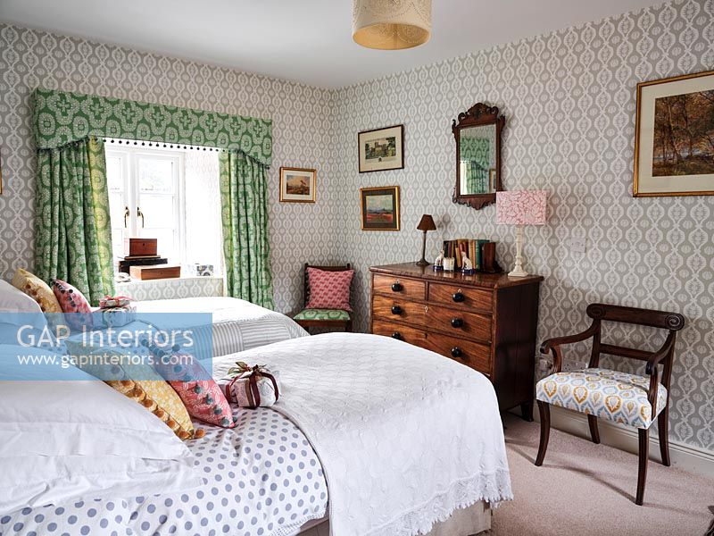 Patterned wallpaper, curtains and furnishings in eclectic country bedroom 