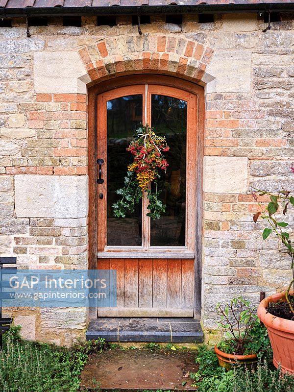 Christmas wreath on wooden and glass door of country house 