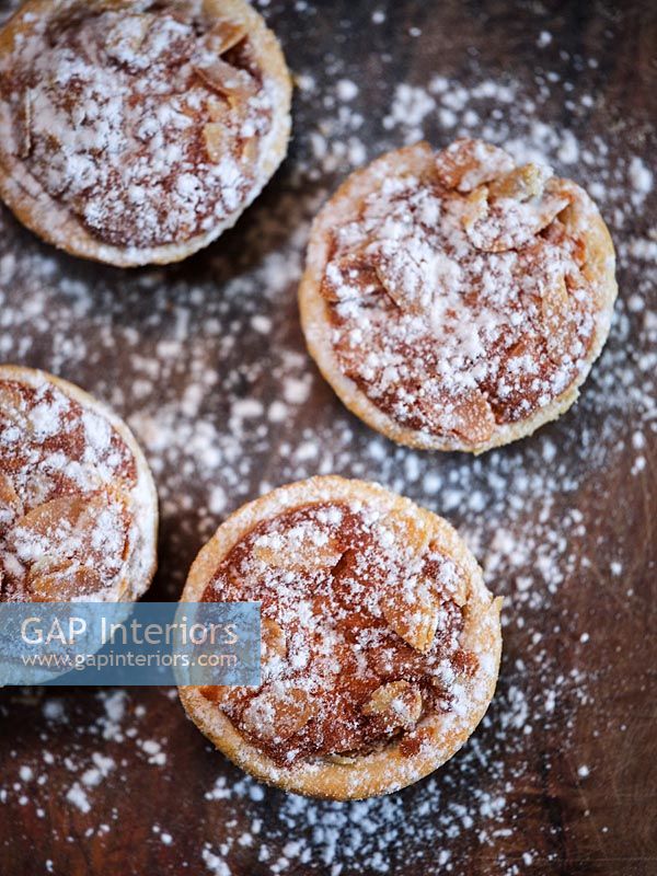 Detail of mince pies on wooden chopping board 