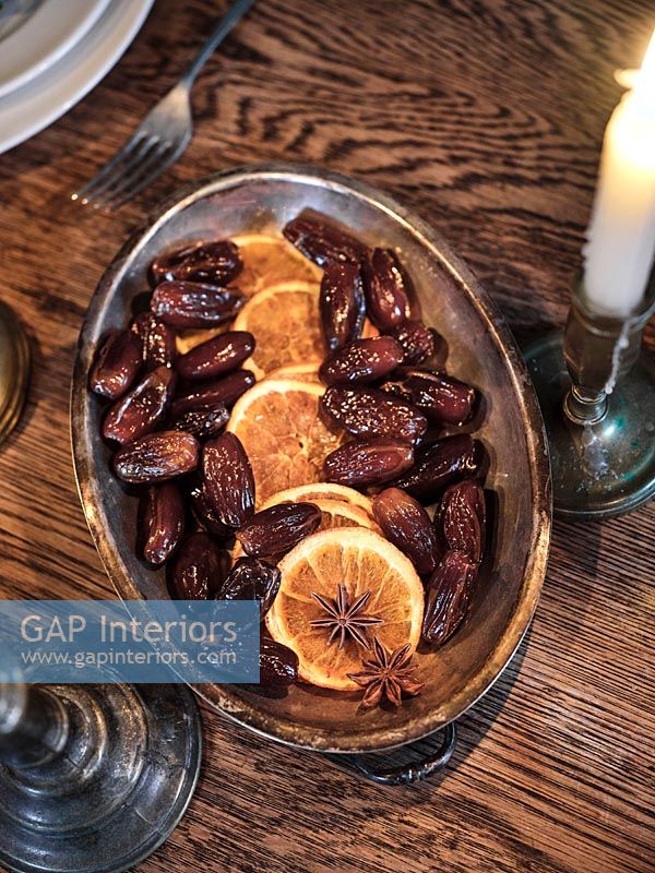Dates and orange slices on silver plate - dining table detail at Christmas 