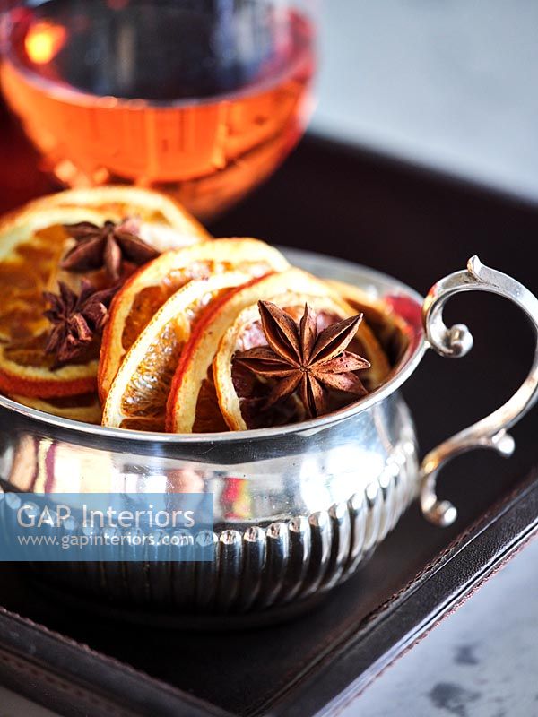 Silver bowl with slices of dried orange and star anise 