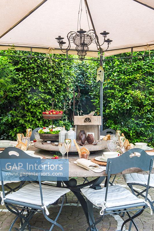 Outdoor dining area with Lazy Susan table under large parasol 
