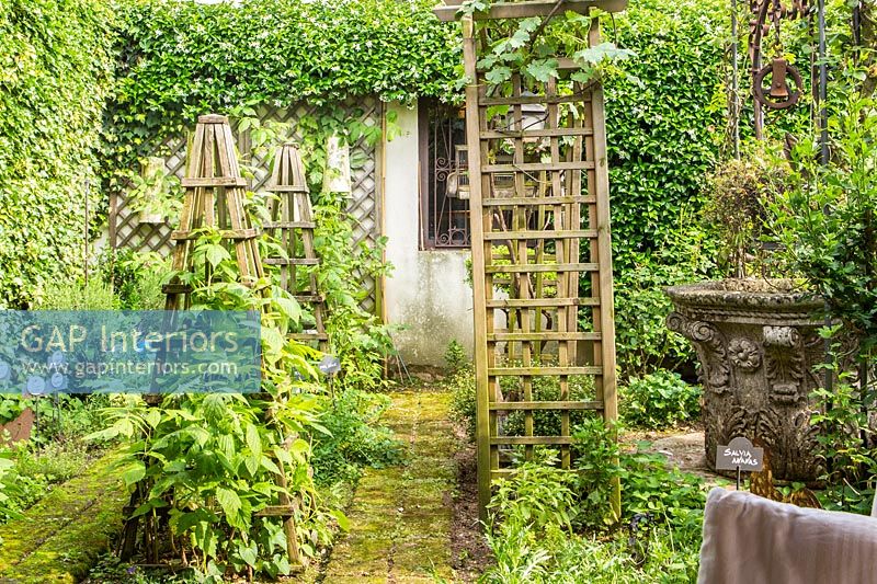 View of country garden with wooden obelisks 