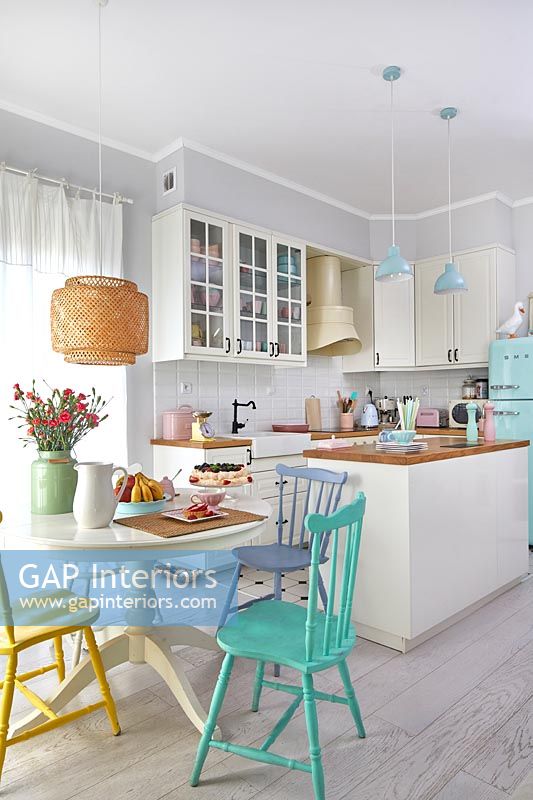 Kitchen diner in small open plan living space decorated in pastel colours 