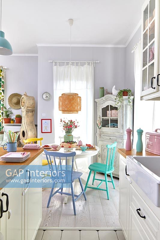 Modern kitchen-diner with pastel accessories in small open plan living space