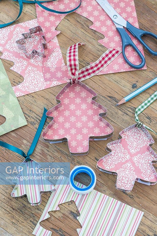 Metal cookie cutters lined with patterned card and ribbons added for hanging