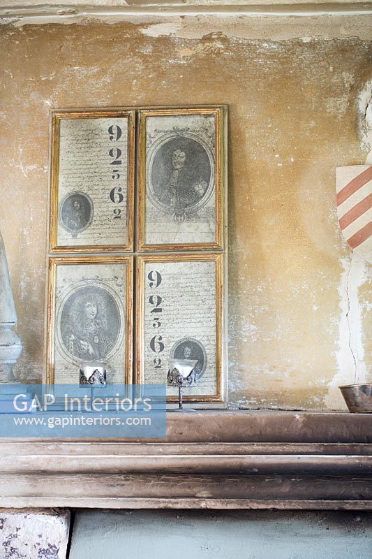 Classic portraits and artwork on exposed plaster wall 
