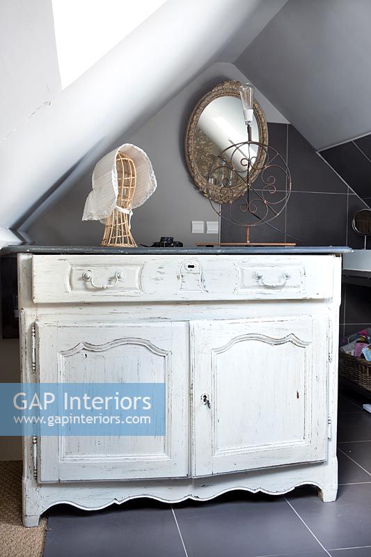 Sideboard with distressed paint in modern bathroom 