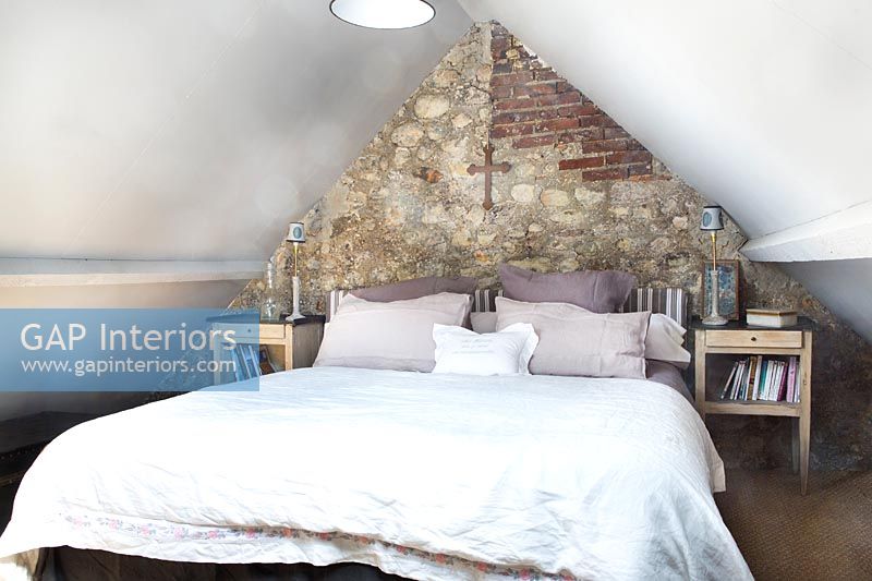 Country bedroom with exposed stone and brick wall 