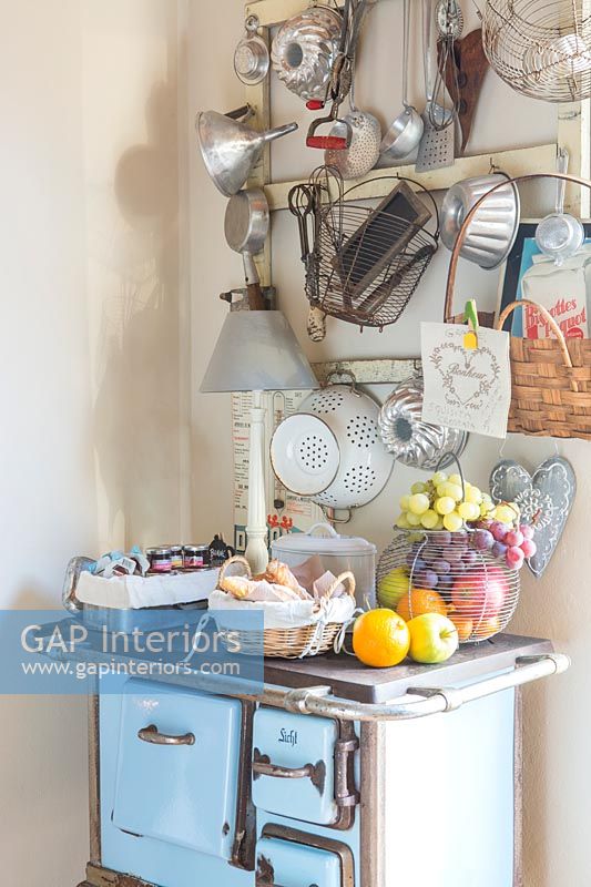 Tiny old stove used as storage table and cabinet in country kitchen 