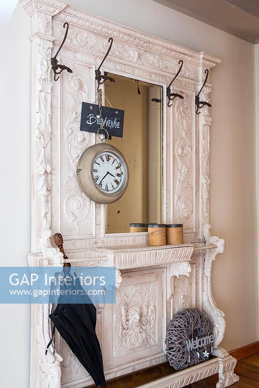 Mirror stand and coat hooks in country hallway 
