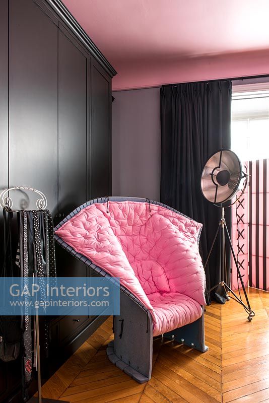 Unusual modern pink upholstered chair in black and pink bedroom 