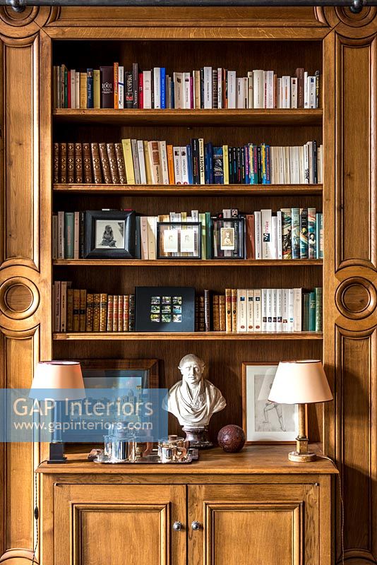 Classic wooden panelled living room with built-in bookshelves 