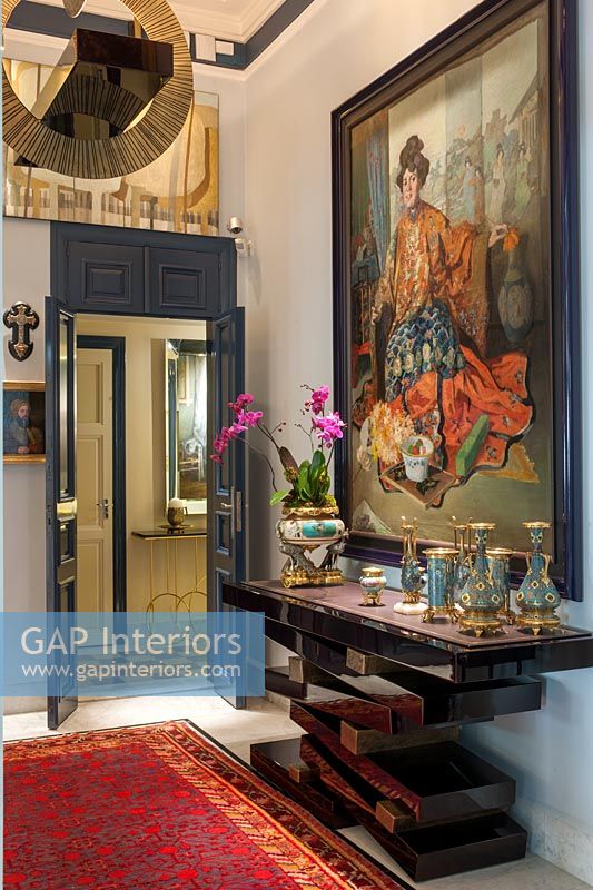 Large classic painting and unusual console table in hallway 