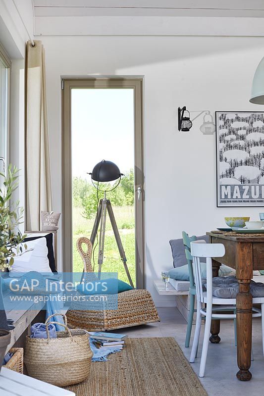 Tripod lamp in window of modern country living room 