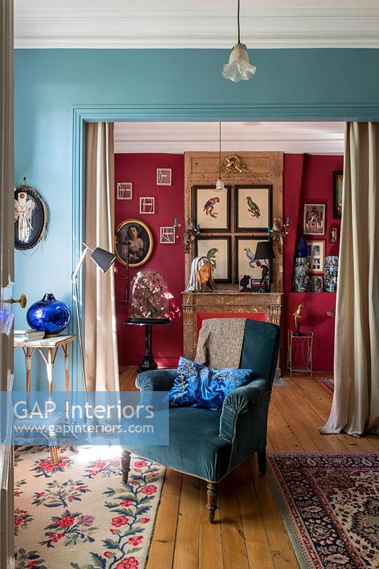 Blue armchair in classic style living room with colourfully painted walls 