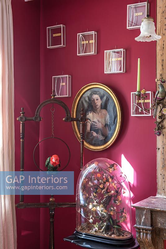 Display of classic paintings and modern artwork on dark red painted wall