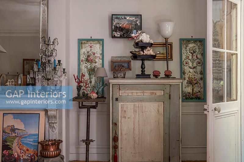 Rustic cabinet surrounded by ornaments and paintings 
