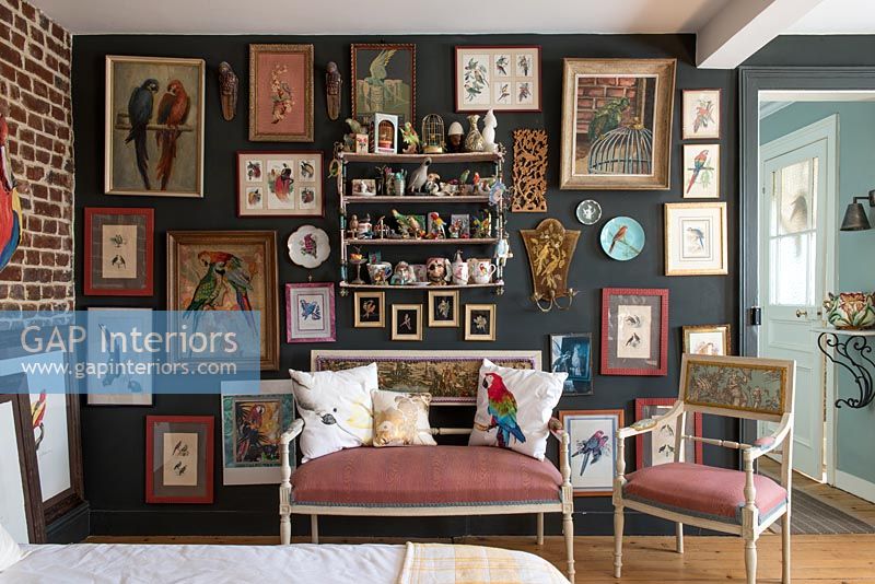 Eclectic bedroom with wall displaying paintings and ornaments 