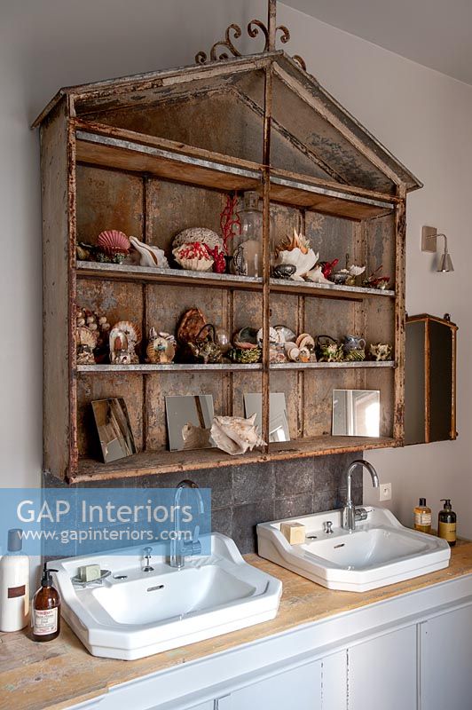 Vintage shelf unit above double sinks in modern country bathroom 