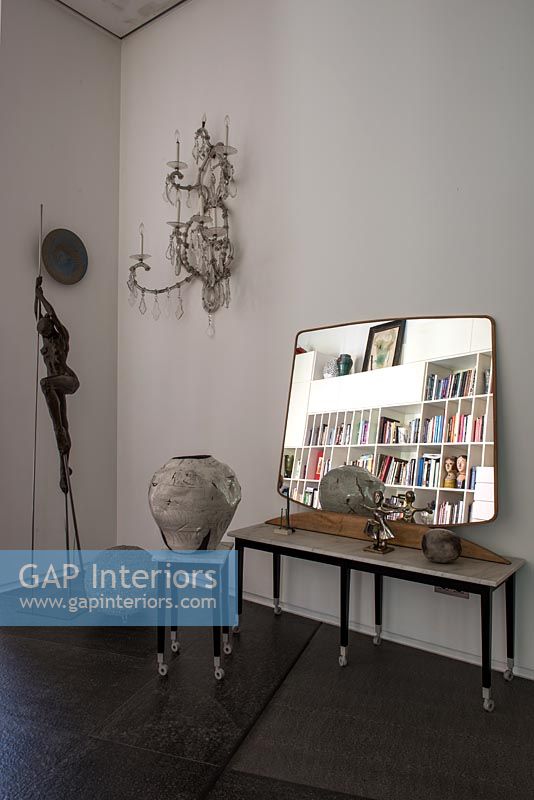 Mirror on side table with sculptures 