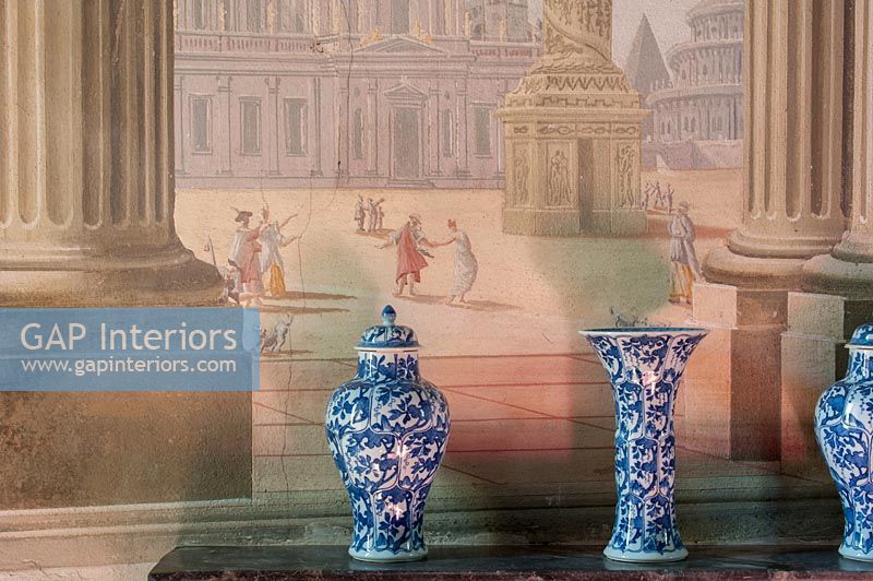 Blue and white vases next to fresco wall 