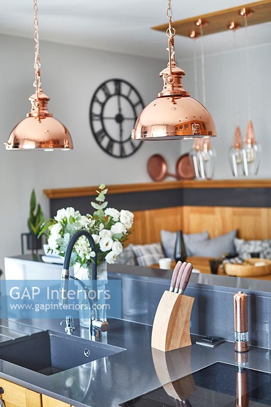 Modern wooden kitchen with copper light fittings 