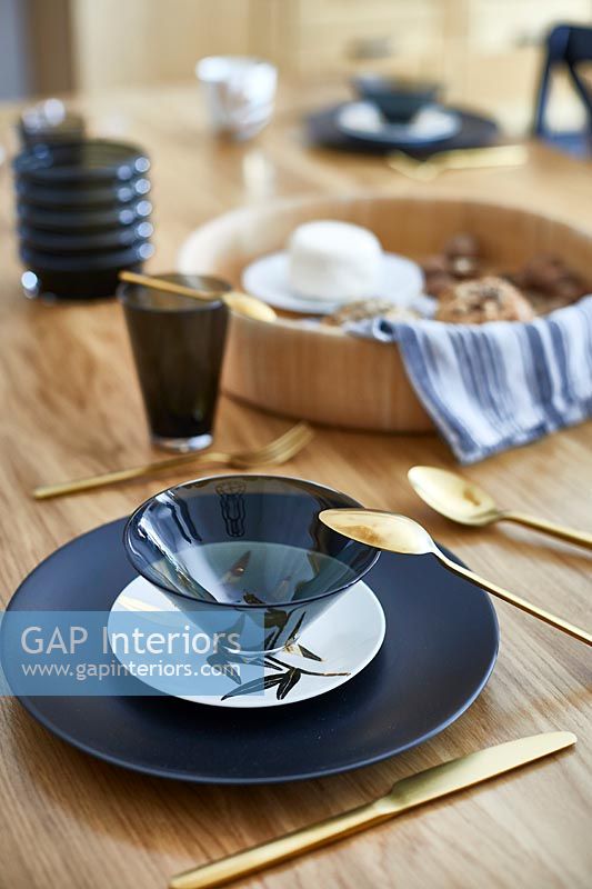 Black, white and gold crockery on dining table - detail 