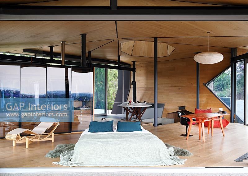 Contemporary timber bedroom with unusual wooden ceiling and walls 