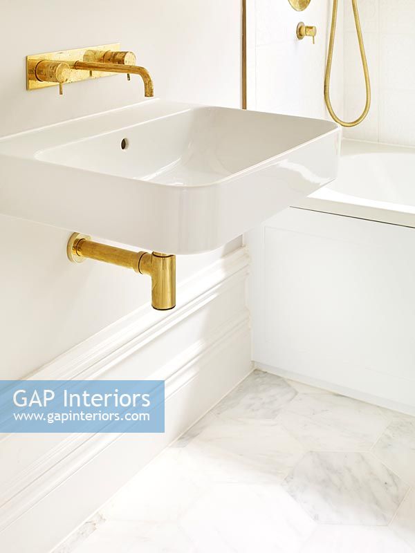 Modern bathroom sink detail with gold taps 