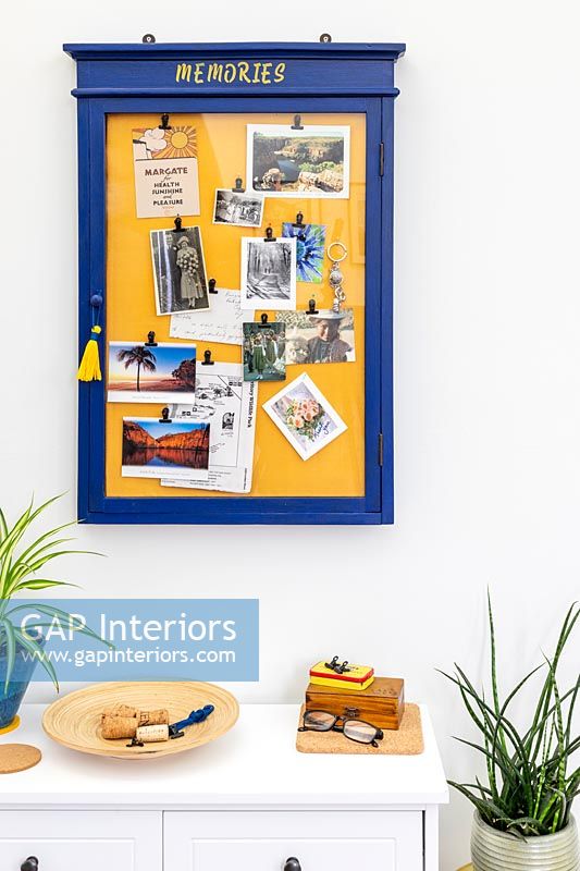 Blue and yellow memories notice board on modern living room wall 